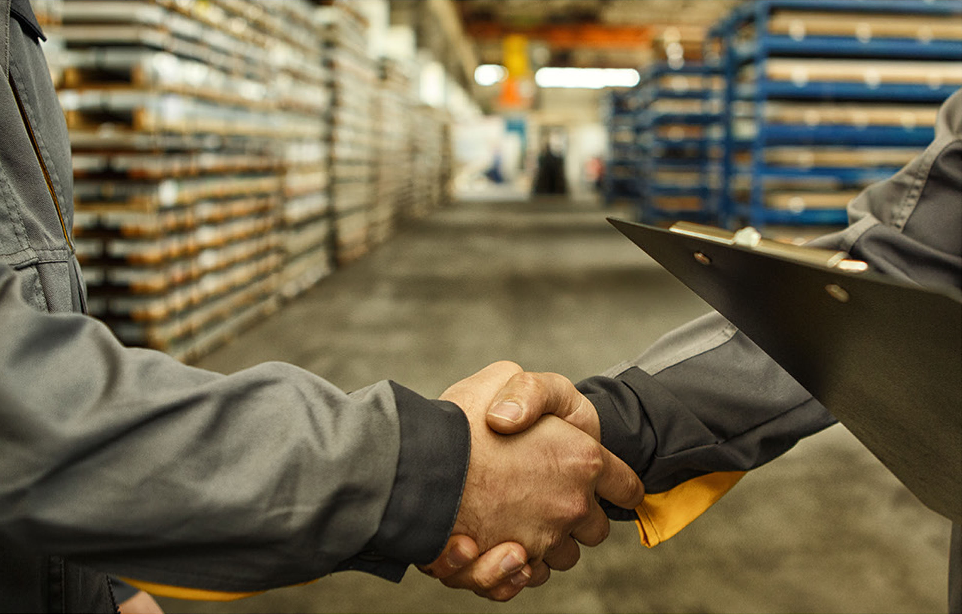 Ejecutivos de empresas comerciales estrechando manos en centro logístico, simbolizando acuerdos de importación y exportación