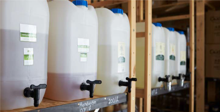 Contenedores de agroquímicos líquidos con válvulas en bodega industrial
