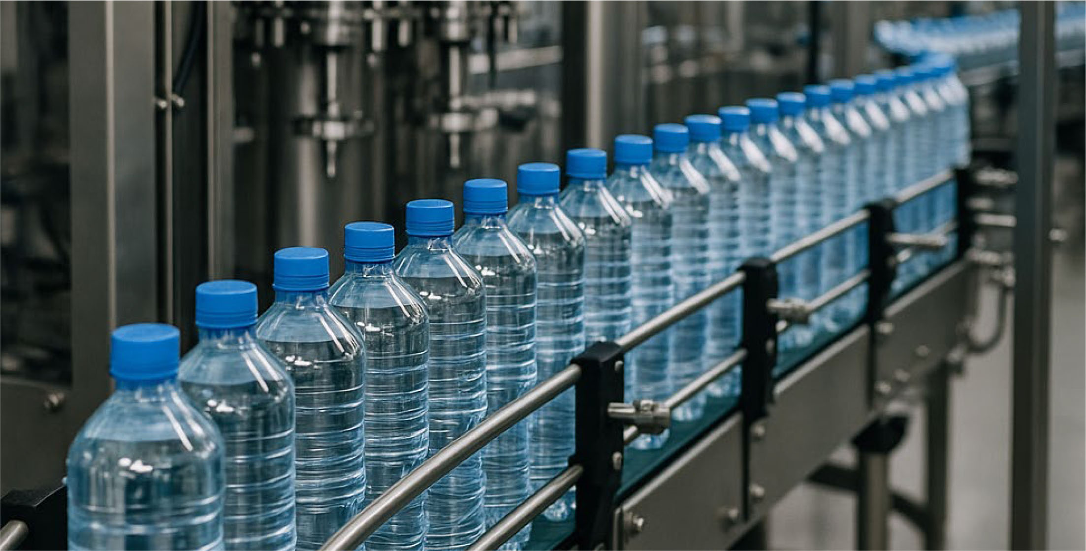 Botellas de agua en línea de producción representando productos bebestibles garantizables