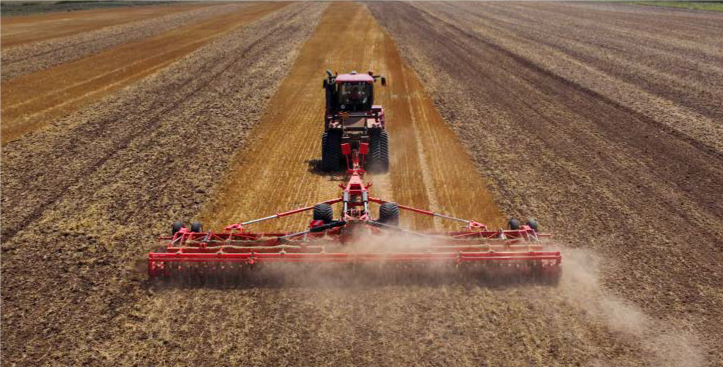 Tractor arando campo agrícola como ejemplo de maquinaria agrícola garantizable